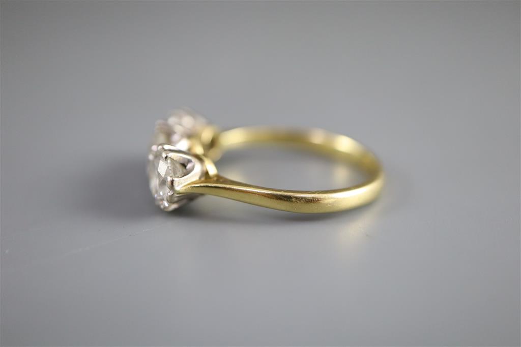 A modern 18ct gold and three stone brilliant cut diamond ring,